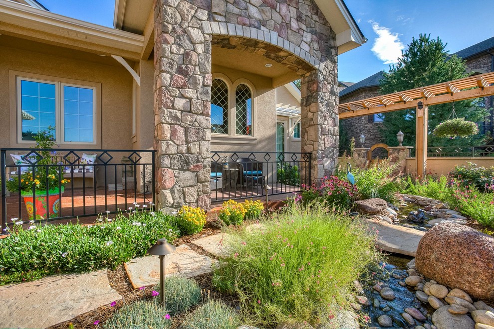 Inspiration for a mid-sized transitional partial sun front yard stone walkway in Denver.