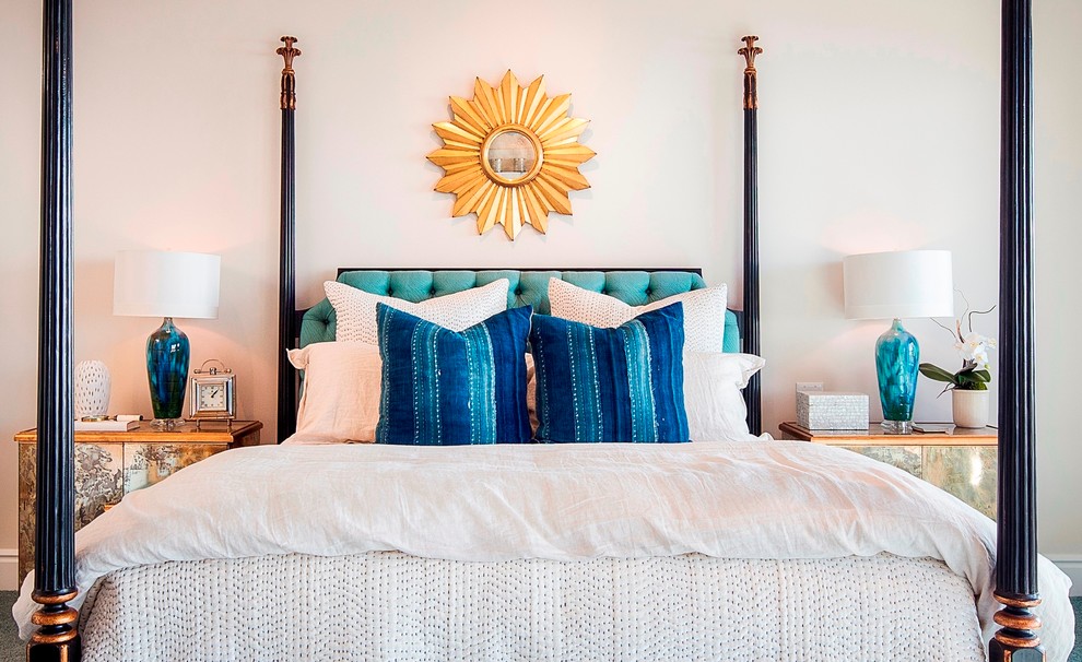 This is an example of a large beach style master bedroom in Orange County with white walls, carpet, a standard fireplace, a plaster fireplace surround and blue floor.