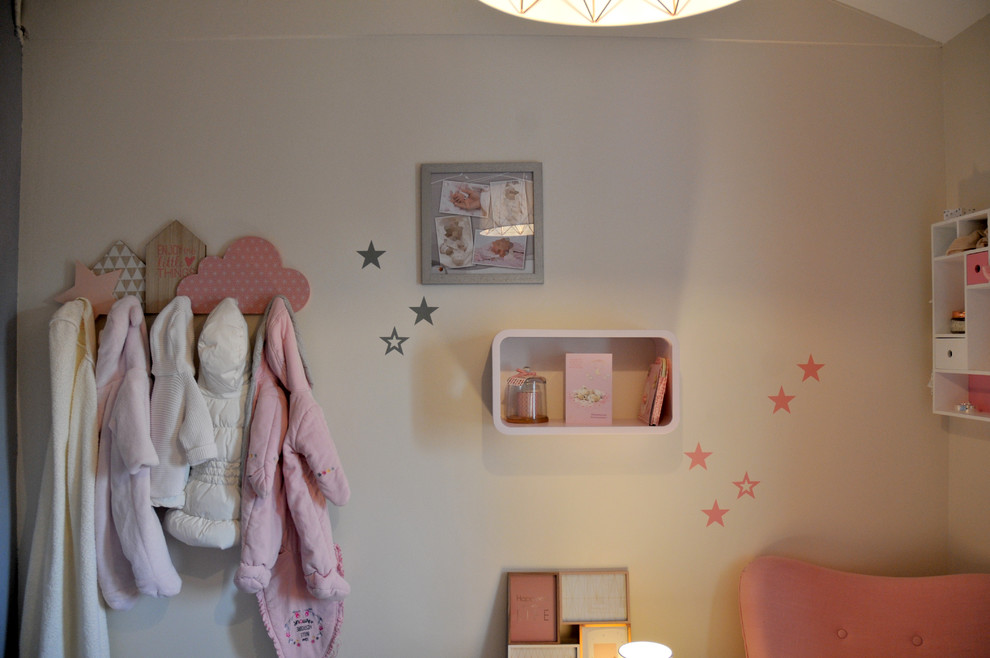 Cette photo montre chambre de bébé fille for fille With un mur beige, un sol en bois brun and un sol marron.