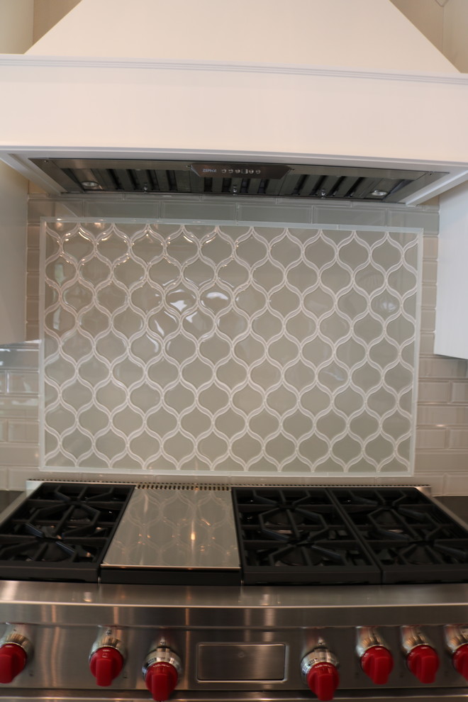 Transitional l-shaped porcelain tile and beige floor eat-in kitchen photo in Austin with a farmhouse sink, shaker cabinets, white cabinets, quartzite countertops, gray backsplash, glass tile backsplash, stainless steel appliances, two islands and black countertops