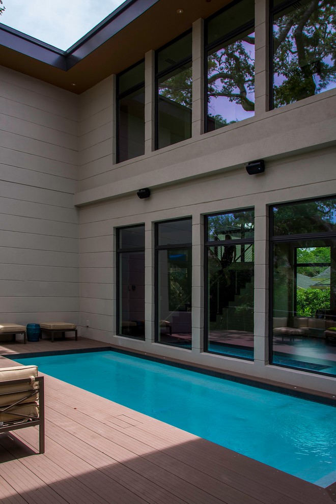 Photo of a small modern side yard rectangular pool in Tampa with decking.