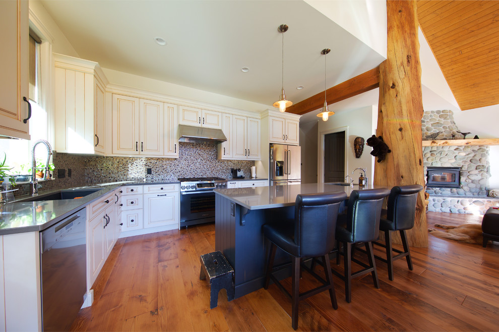Mid-sized country galley open plan kitchen in Vancouver with an undermount sink, louvered cabinets, white cabinets, multi-coloured splashback, ceramic splashback, stainless steel appliances, medium hardwood floors and with island.
