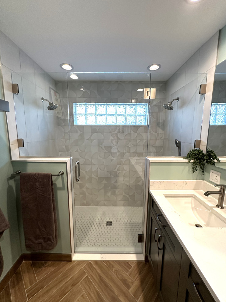 Mid-sized 1960s master gray tile and ceramic tile porcelain tile, brown floor and double-sink walk-in shower photo in Detroit with shaker cabinets, gray cabinets, a two-piece toilet, green walls, an undermount sink, quartz countertops, a hinged shower door, white countertops, a niche and a built-in vanity