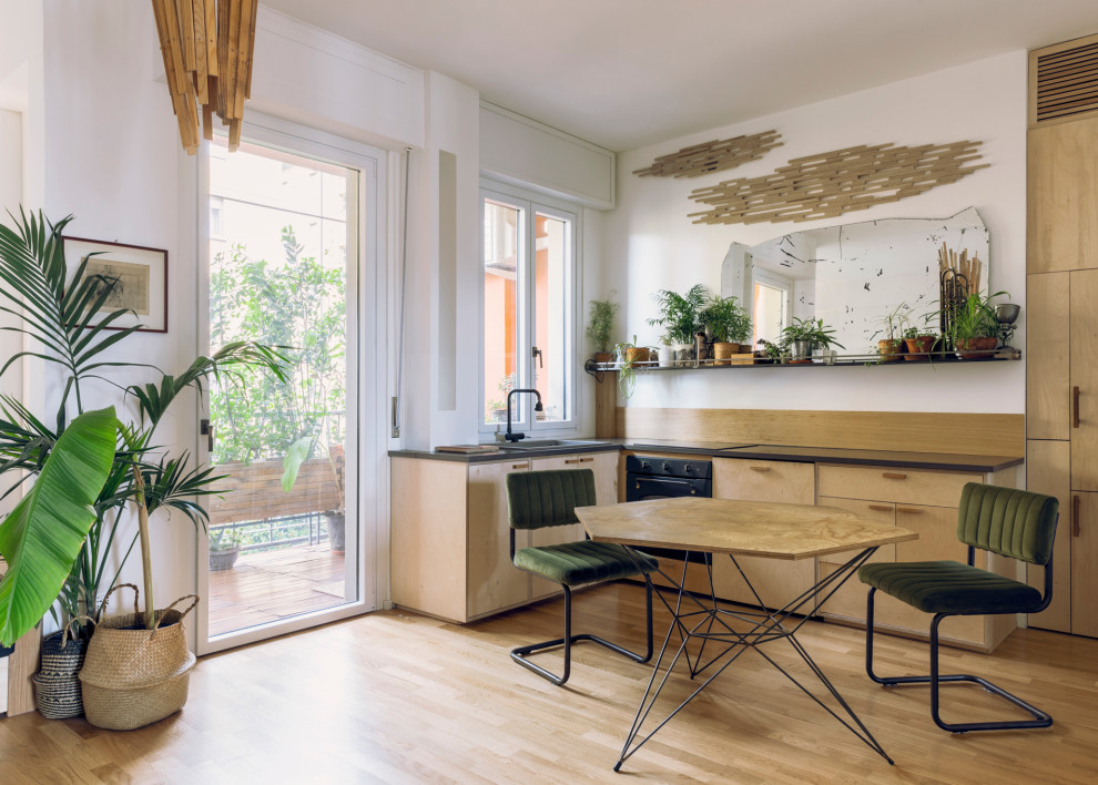 ミラノにある低価格の小さなコンテンポラリースタイルのおしゃれなL型キッチン (中間色木目調キャビネット、珪岩カウンター、黒いキッチンカウンター) の写真