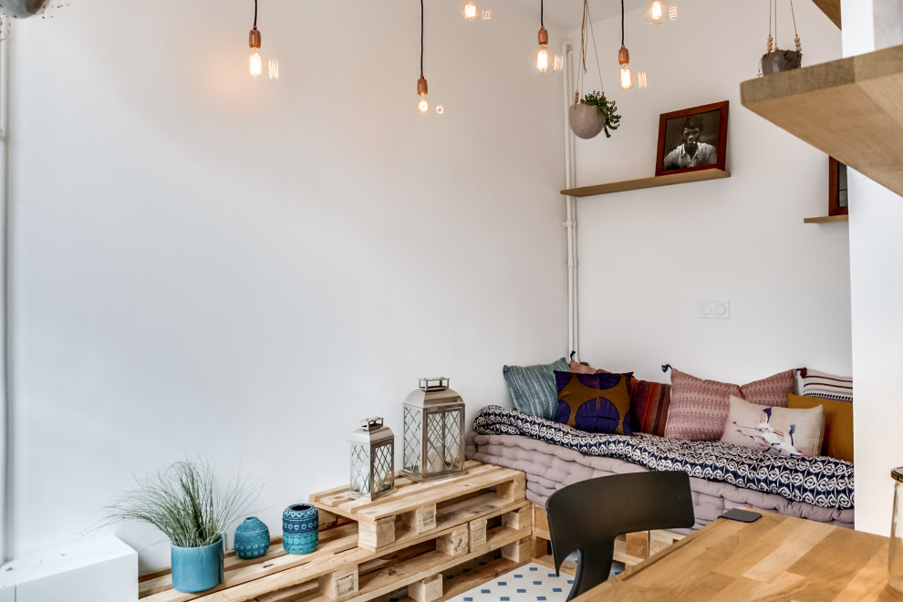 Medium sized bohemian home studio in Paris with white walls, ceramic flooring, a freestanding desk and blue floors.