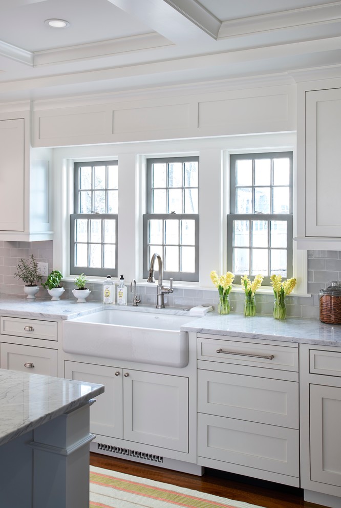 Inspiration for a large transitional single-wall eat-in kitchen in Minneapolis with a farmhouse sink, shaker cabinets, white cabinets, marble benchtops, grey splashback, subway tile splashback, stainless steel appliances, dark hardwood floors and with island.