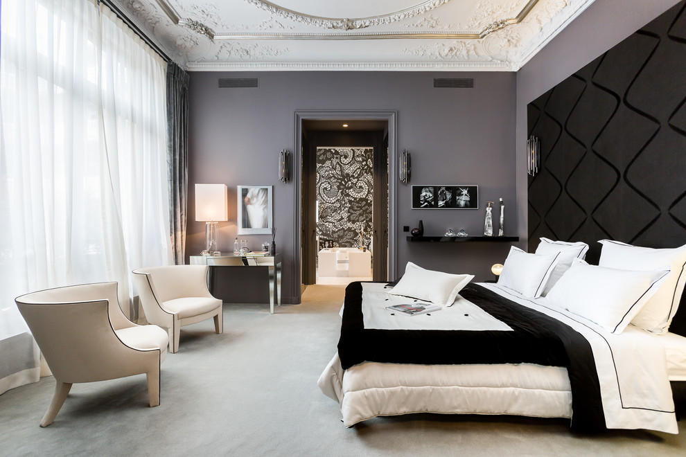 This is an example of a large transitional master bedroom in Paris with grey walls, carpet and no fireplace.