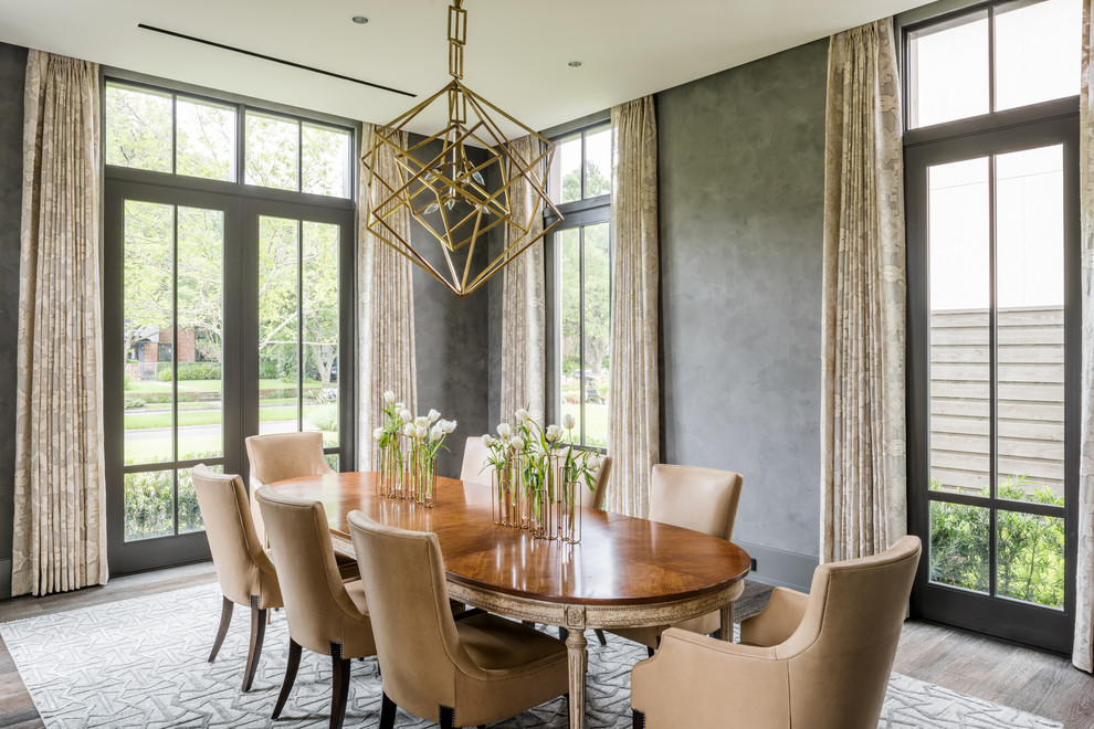 This is an example of a transitional dining room in Houston with grey walls and dark hardwood floors.
