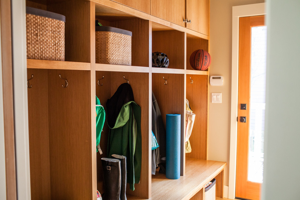 Mudroom - transitional light wood floor mudroom idea in Portland with beige walls and a light wood front door
