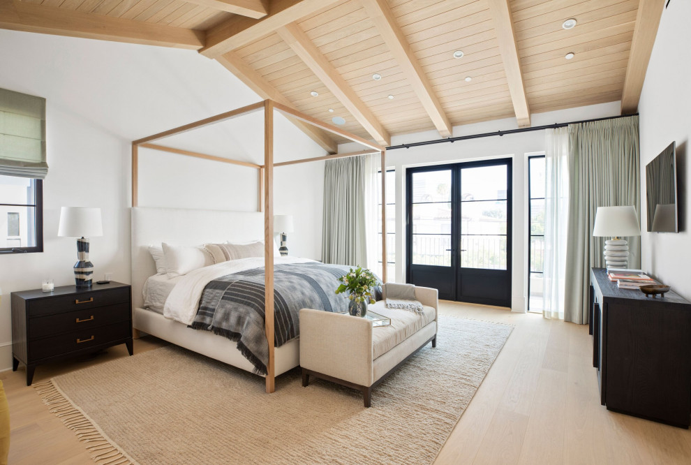 Design ideas for a large transitional master bedroom in Los Angeles with white walls, light hardwood floors, a standard fireplace, a stone fireplace surround, beige floor and timber.