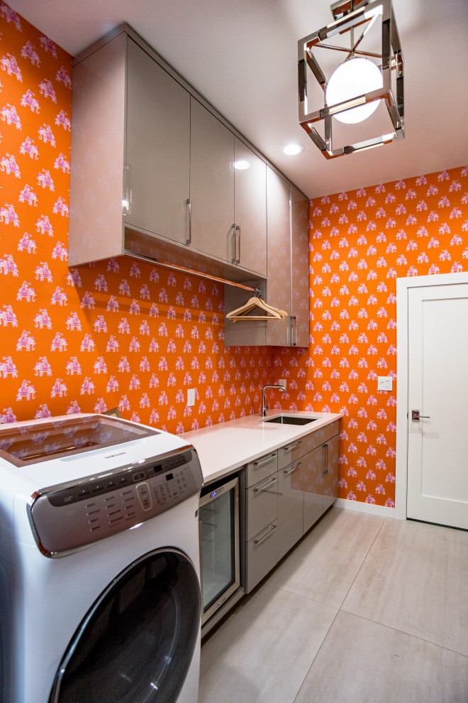 Large modern galley utility room in Other with a drop-in sink, flat-panel cabinets, grey cabinets, granite benchtops, orange walls, ceramic floors, a side-by-side washer and dryer, white floor and white benchtop.