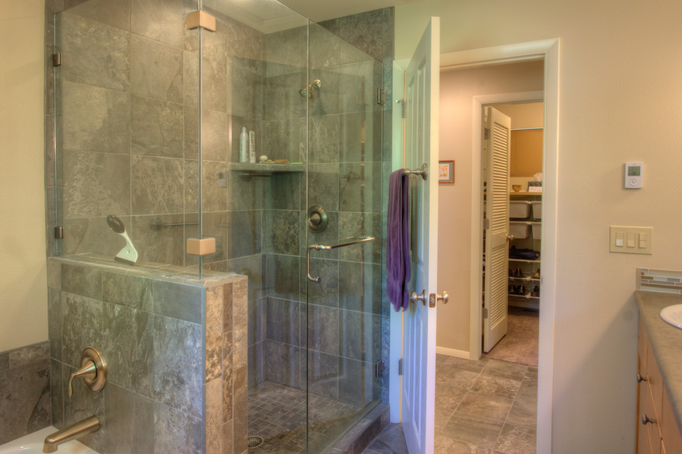This is an example of a mid-sized traditional master bathroom in Denver with a drop-in sink, flat-panel cabinets, medium wood cabinets, laminate benchtops, a drop-in tub, an alcove shower, brown tile, ceramic tile, beige walls and ceramic floors.