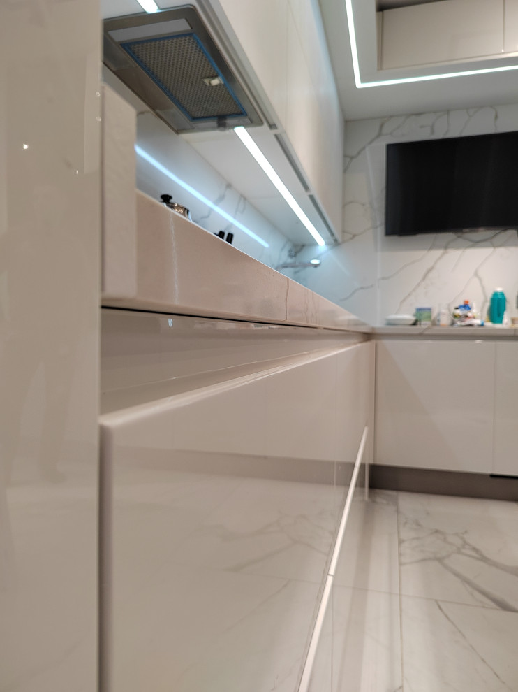 Inspiration for a large contemporary l-shaped eat-in kitchen in Moscow with an undermount sink, flat-panel cabinets, white cabinets, quartz benchtops, white splashback, engineered quartz splashback, black appliances and white benchtop.