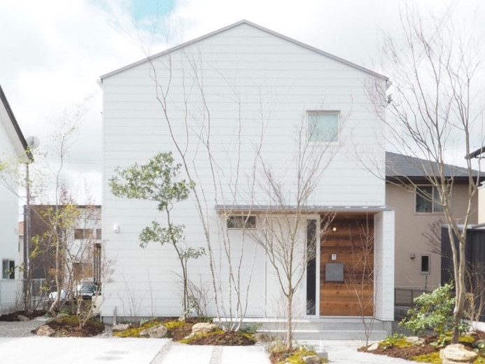 Mittelgroßes, Zweistöckiges Nordisches Einfamilienhaus mit Mix-Fassade, weißer Fassadenfarbe, Satteldach, Blechdach und grauem Dach in Sonstige