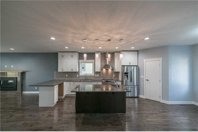 Inspiration for a mid-sized transitional l-shaped vinyl floor open concept kitchen remodel in Edmonton with an undermount sink, shaker cabinets, white cabinets, concrete countertops, multicolored backsplash, mosaic tile backsplash, stainless steel appliances and an island