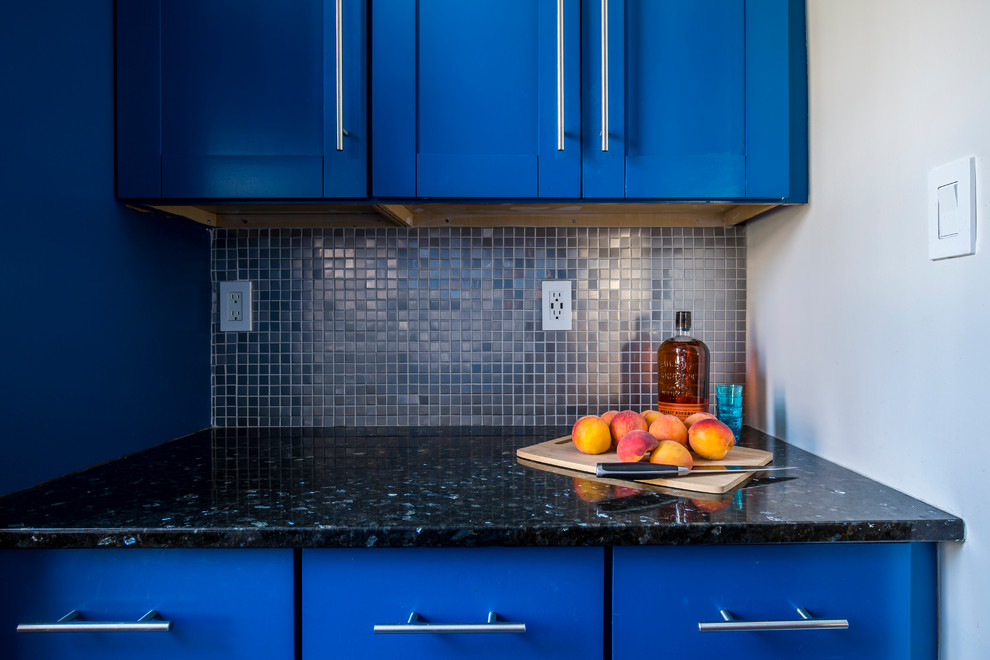 Photo of a small eclectic galley separate kitchen in New York with an undermount sink, shaker cabinets, blue cabinets, quartz benchtops, grey splashback, mosaic tile splashback, stainless steel appliances, ceramic floors and no island.