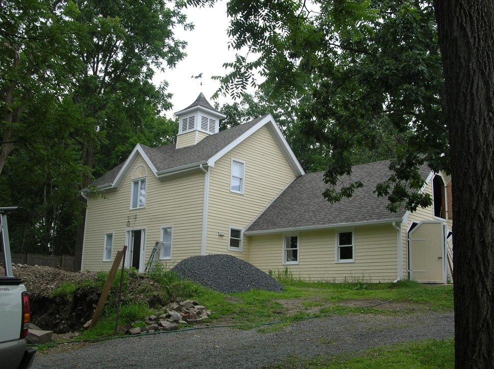 Photo of a large traditional three-storey yellow exterior in Boston with wood siding and a gable roof.