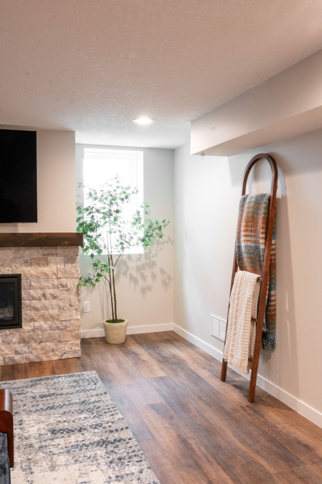 This is an example of a small traditional open concept family room in Other with a music area, beige walls, vinyl floors, a ribbon fireplace, a stone fireplace surround, a wall-mounted tv and brown floor.