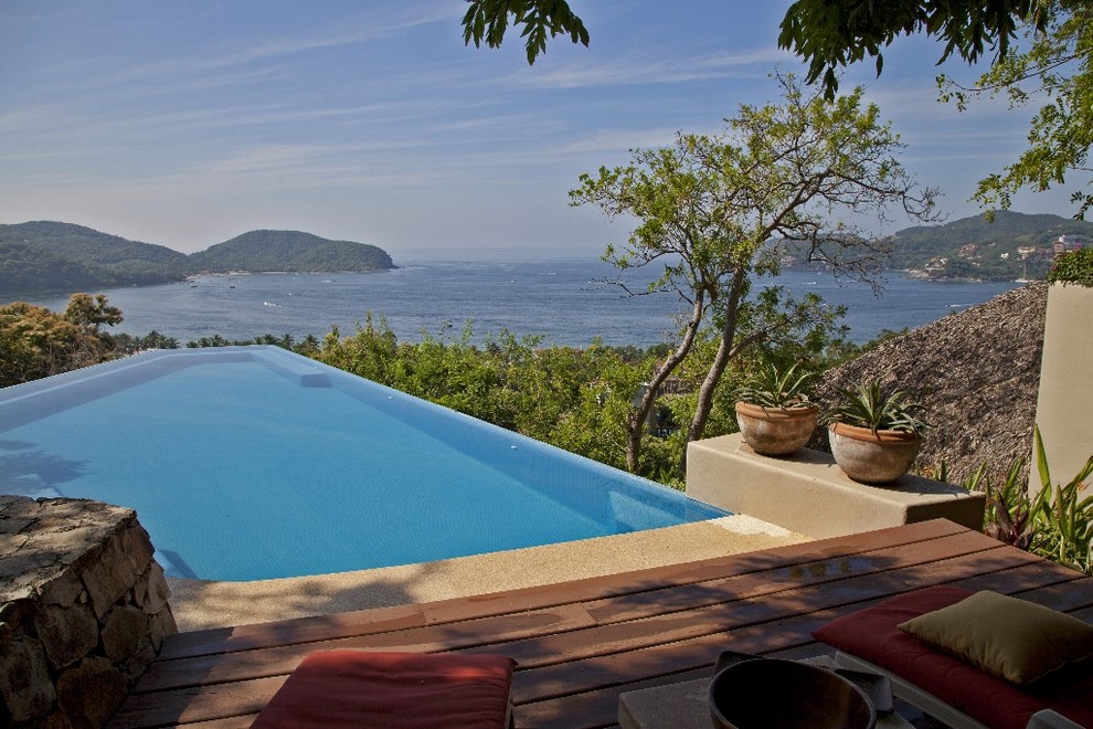 Inspiration for a large coastal backyard concrete paver and custom-shaped infinity pool remodel