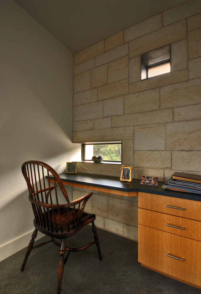 This is an example of a contemporary home office in Austin with concrete floors.