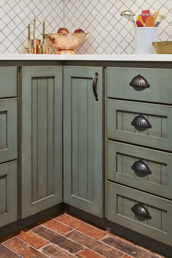 Bild på ett litet vit vitt kök, med en undermonterad diskho, luckor med profilerade fronter, gröna skåp, bänkskiva i kvarts, vitt stänkskydd, stänkskydd i keramik, rostfria vitvaror, klinkergolv i porslin, en köksö och flerfärgat golv