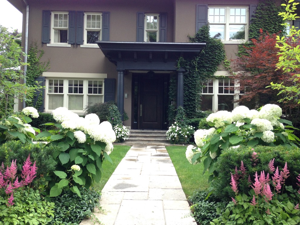 Photo of a large contemporary front yard formal garden in Toronto with a garden path and concrete pavers.