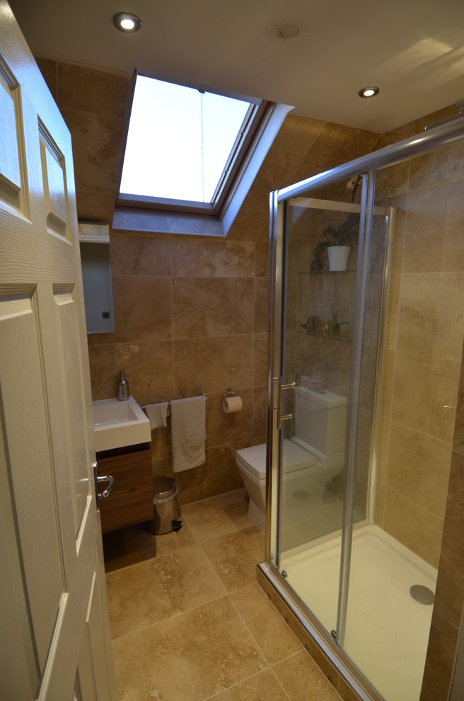 Inspiration for a small contemporary bathroom in Gloucestershire with a trough sink, flat-panel cabinets, dark wood cabinets, solid surface benchtops, a corner shower, a two-piece toilet, beige tile, stone tile, beige walls and travertine floors.