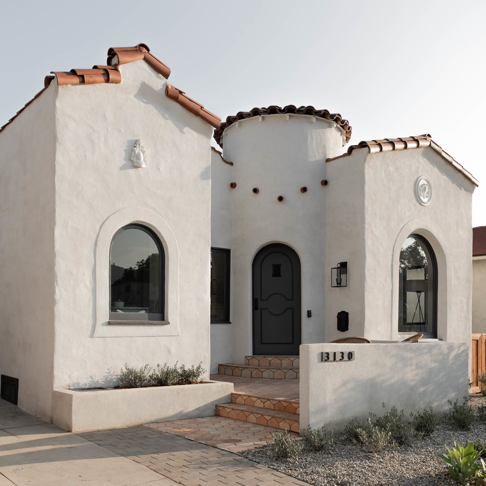 Inspiration for a mediterranean one-storey white house exterior in Los Angeles with a gable roof and a tile roof.