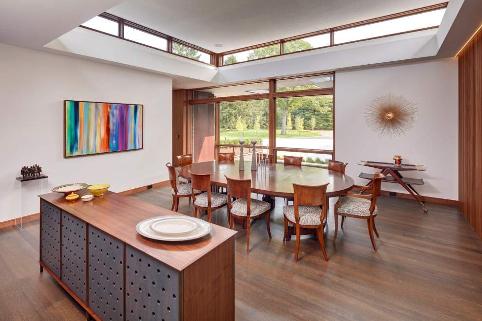 Photo of a contemporary dining room in Detroit with white walls, dark hardwood floors and brown floor.