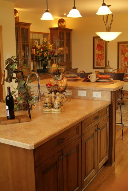 Eat-in kitchen - large rustic u-shaped medium tone wood floor eat-in kitchen idea with a double-bowl sink, beaded inset cabinets, medium tone wood cabinets, granite countertops, beige backsplash, stainless steel appliances and an island