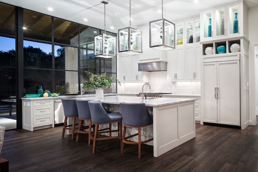 Inspiration for a transitional l-shaped open plan kitchen in Austin with an undermount sink, shaker cabinets, white cabinets, white splashback, stainless steel appliances, dark hardwood floors and with island.