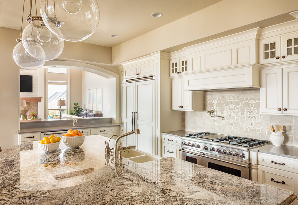Large transitional enclosed kitchen photo with a double-bowl sink, beaded inset cabinets, white cabinets, granite countertops, gray backsplash, cement tile backsplash, stainless steel appliances, an island and gray countertops