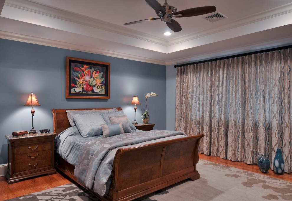 Mid-sized traditional master bedroom in New York with blue walls, medium hardwood floors and no fireplace.