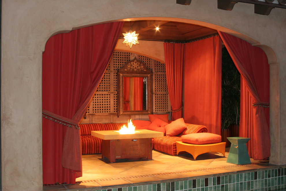Mid-sized mediterranean backyard patio in Los Angeles with a fire feature, tile and a pergola.