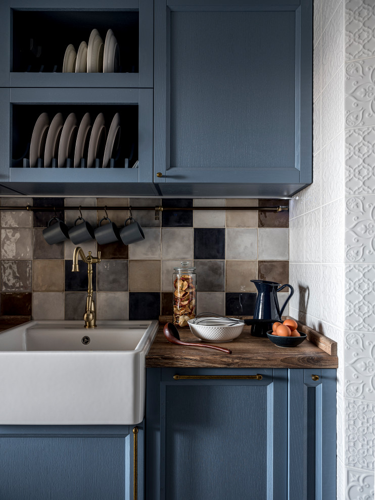 Diseño de cocina comedor tradicional de tamaño medio con armarios con paneles empotrados, puertas de armario azules, encimera de madera y encimeras beige
