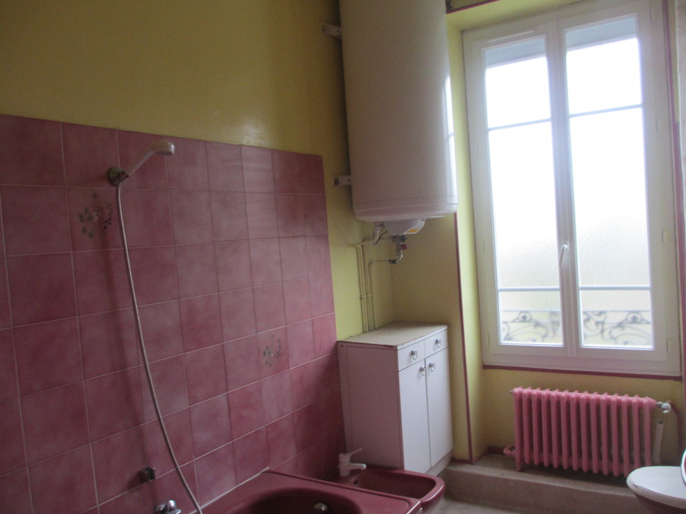 Inredning av ett mellanstort badrum, med rosa kakel och gula väggar
