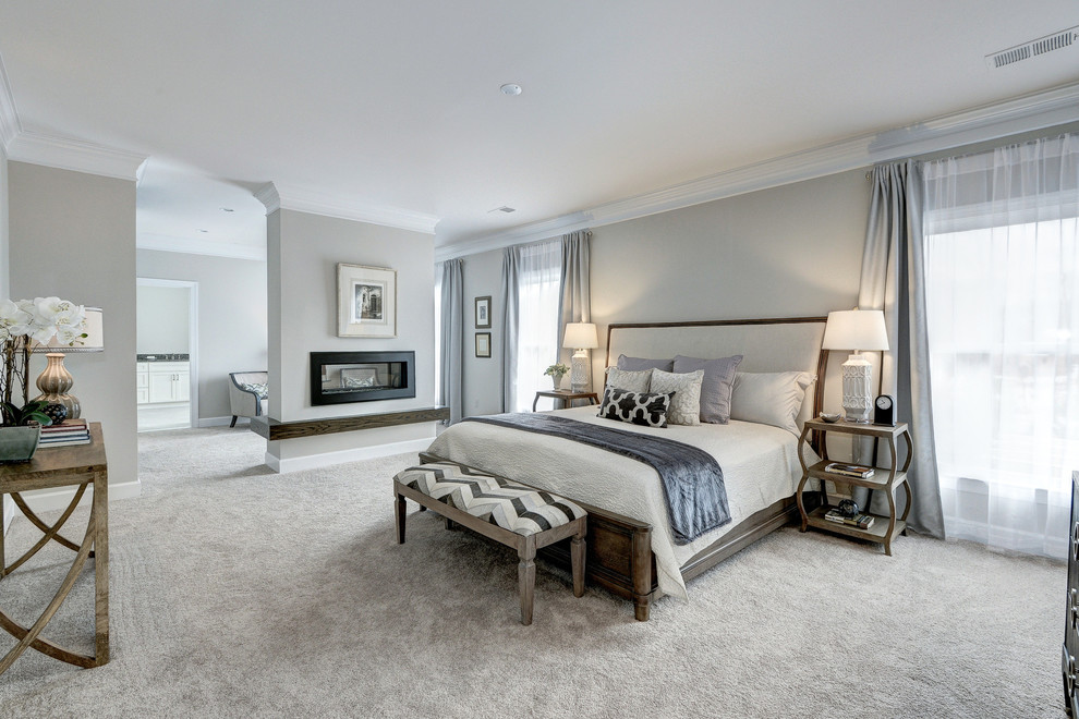 Inspiration for a large transitional master bedroom in DC Metro with carpet, a two-sided fireplace, a plaster fireplace surround, beige walls and beige floor.
