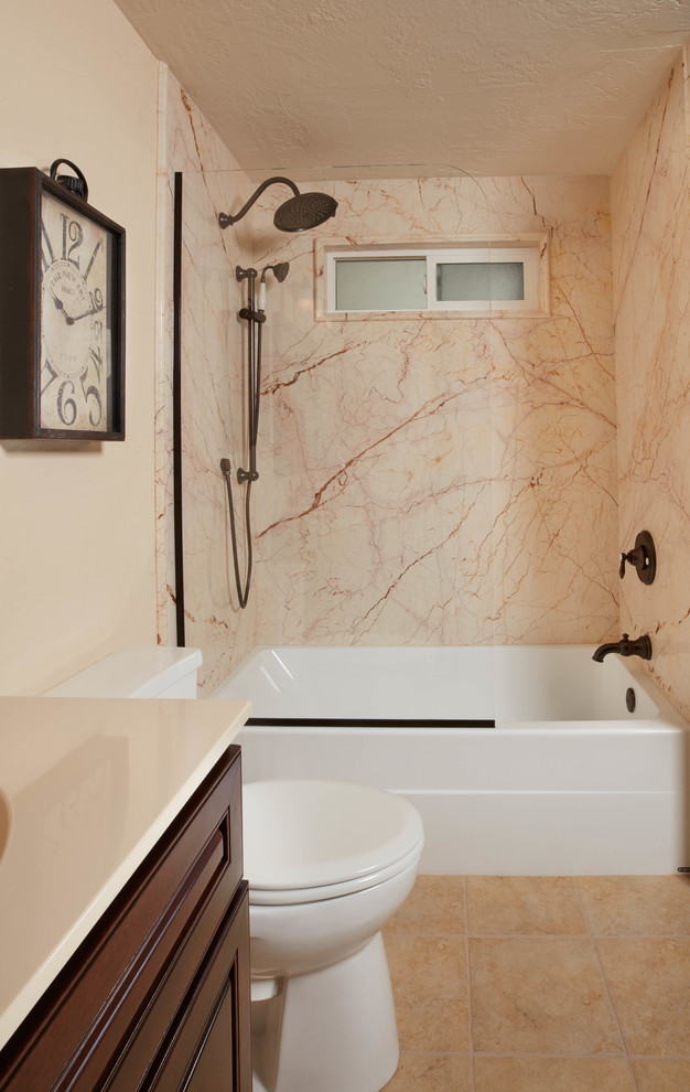 Photo of a mid-sized transitional 3/4 bathroom in Wichita with raised-panel cabinets, brown cabinets, an alcove tub, a shower/bathtub combo, beige tile, stone slab, beige walls, porcelain floors, an undermount sink, engineered quartz benchtops, beige floor and an open shower.