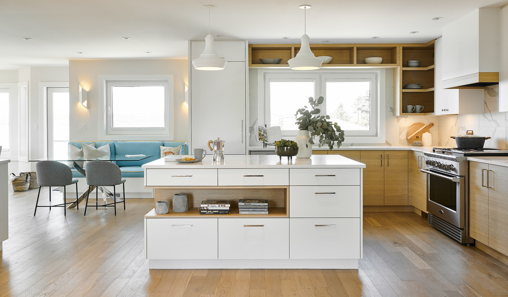 Photo of a mid-sized scandinavian l-shaped eat-in kitchen in Vancouver with an undermount sink, flat-panel cabinets, white cabinets, quartzite benchtops, white splashback, ceramic splashback, stainless steel appliances, light hardwood floors, with island, brown floor and white benchtop.