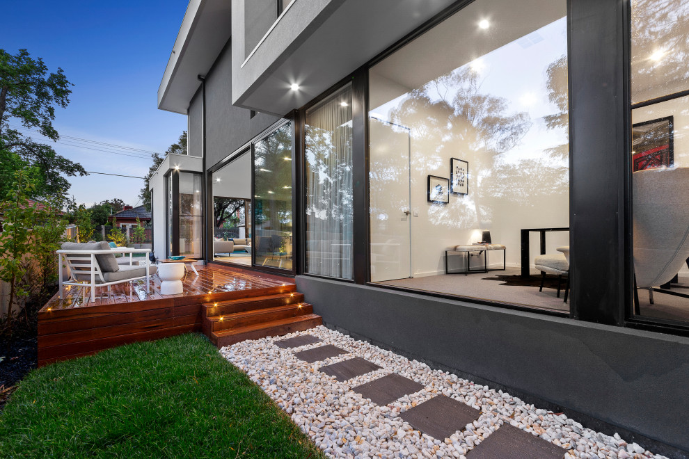 This is an example of a mid-sized contemporary side yard deck in Melbourne with with privacy feature and no cover.