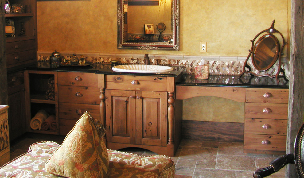 Example of a mid-sized mountain style master beige tile travertine floor and beige floor bathroom design with shaker cabinets, medium tone wood cabinets, yellow walls, granite countertops and a drop-in sink