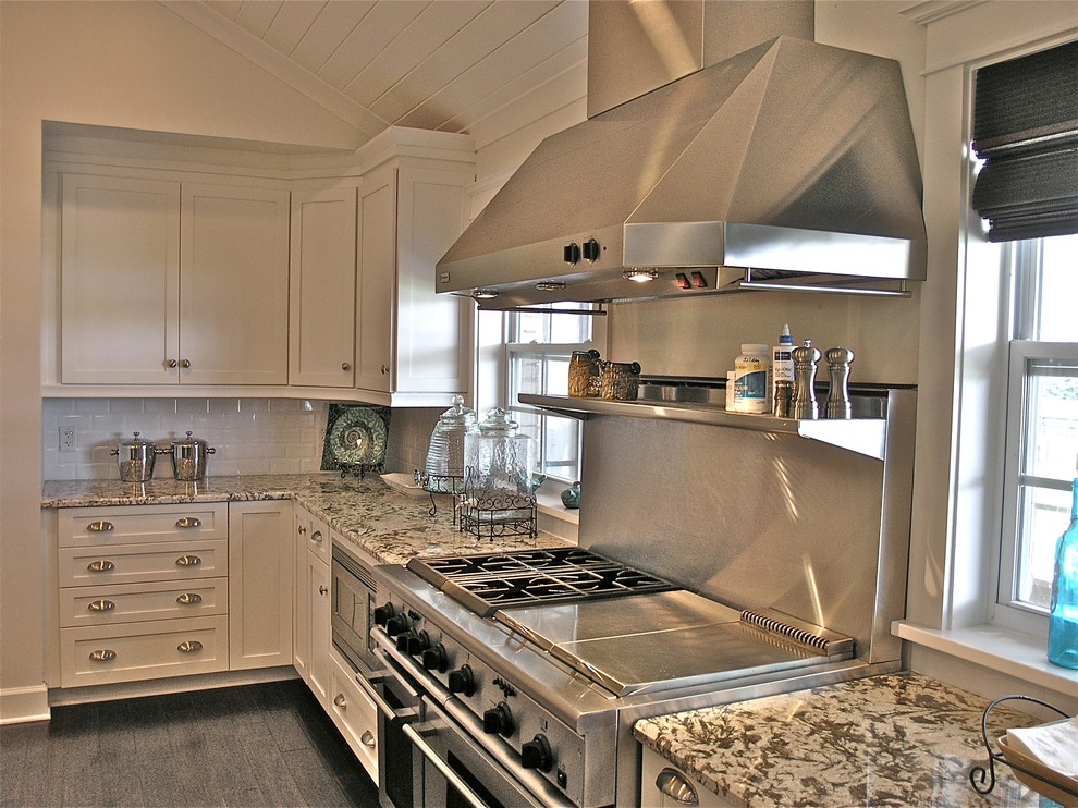 Large transitional u-shaped eat-in kitchen in Jacksonville with an undermount sink, shaker cabinets, white cabinets, granite benchtops, white splashback, subway tile splashback, stainless steel appliances and grey floor.