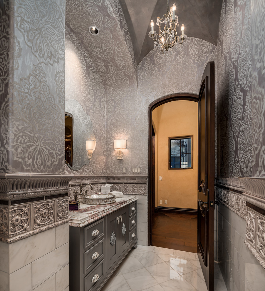 Design ideas for a large modern powder room in Phoenix with raised-panel cabinets, grey cabinets, a two-piece toilet, multi-coloured tile, ceramic tile, multi-coloured walls, marble floors, a drop-in sink, marble benchtops, beige floor and yellow benchtops.