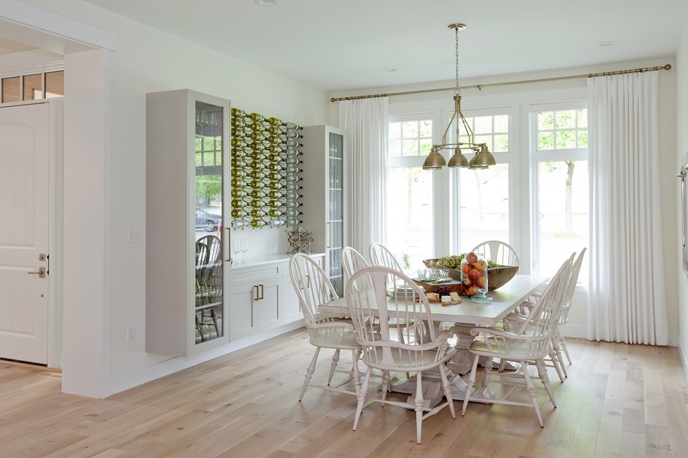 Inspiration for a transitional dining room in Vancouver with white walls and light hardwood floors.