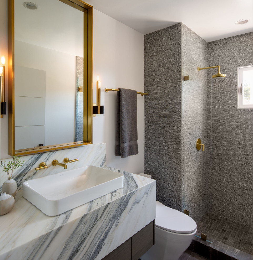 Modern inredning av ett grå grått badrum, med släta luckor, skåp i mellenmörkt trä, en öppen dusch, vita väggar och ett fristående handfat
