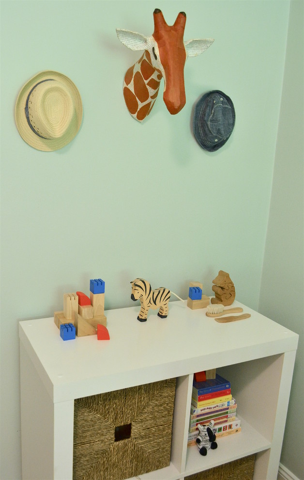 Photo of a small transitional nursery for boys in Philadelphia with blue walls and medium hardwood floors.
