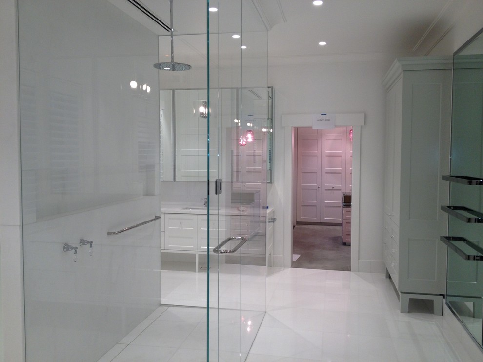 Expansive modern master bathroom in Melbourne with an undermount sink, recessed-panel cabinets, grey cabinets, marble benchtops, a double shower, a wall-mount toilet, white tile, stone slab, white walls and marble floors.