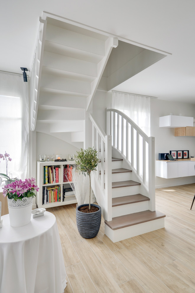 Scandinavian wood l-shaped staircase in Paris with painted wood risers and wood railing.