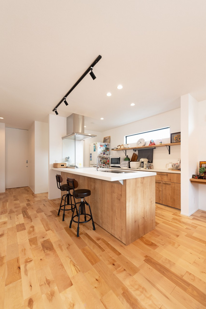 Mid-sized asian galley kitchen in Kyoto with an undermount sink, flat-panel cabinets, medium wood cabinets, medium hardwood floors, a peninsula, brown floor and white benchtop.