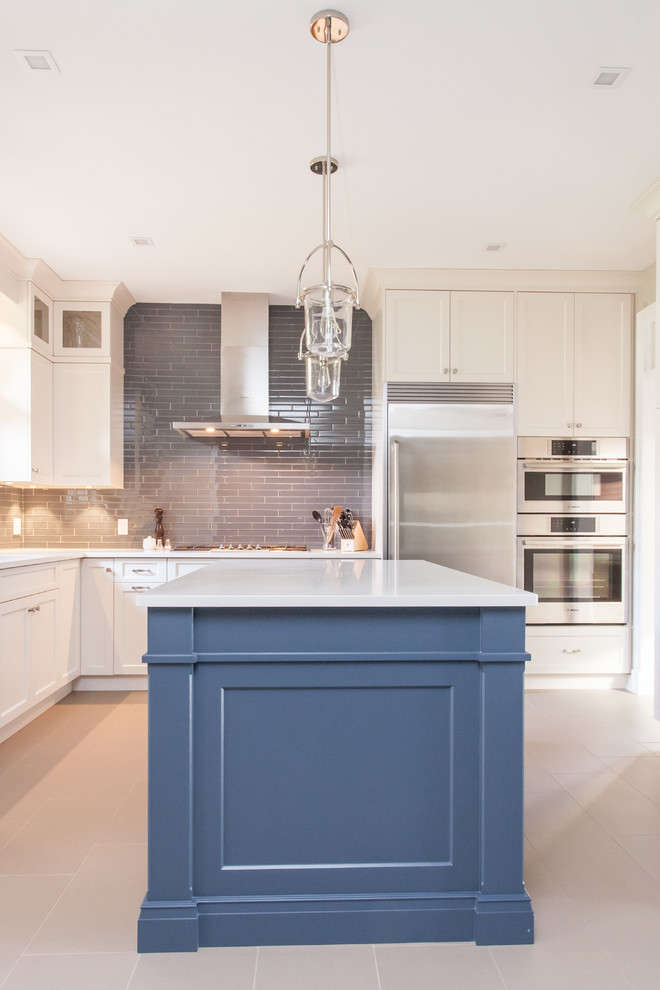 Large transitional u-shaped eat-in kitchen in Toronto with an undermount sink, recessed-panel cabinets, white cabinets, quartz benchtops, grey splashback, subway tile splashback, stainless steel appliances, porcelain floors, with island, grey floor and white benchtop.